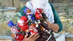 Yapımını annesinden öğrendiği bez bebekler ile ailesine katkı sağlıyor