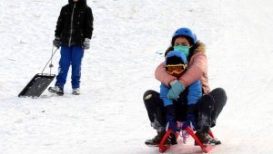 Çocuklar tepsi, poşet ve kızaklarla kaydı