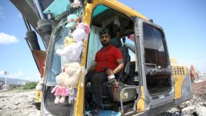 Kaldırdığı enkazlardan çıkan oyuncakları kepçesine asıp çalışıyor