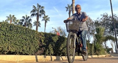 Mersin'de 82 yaşındaki muhtar, mahallesindeki eksikleri bisikletiyle dolaşarak belirliyor
